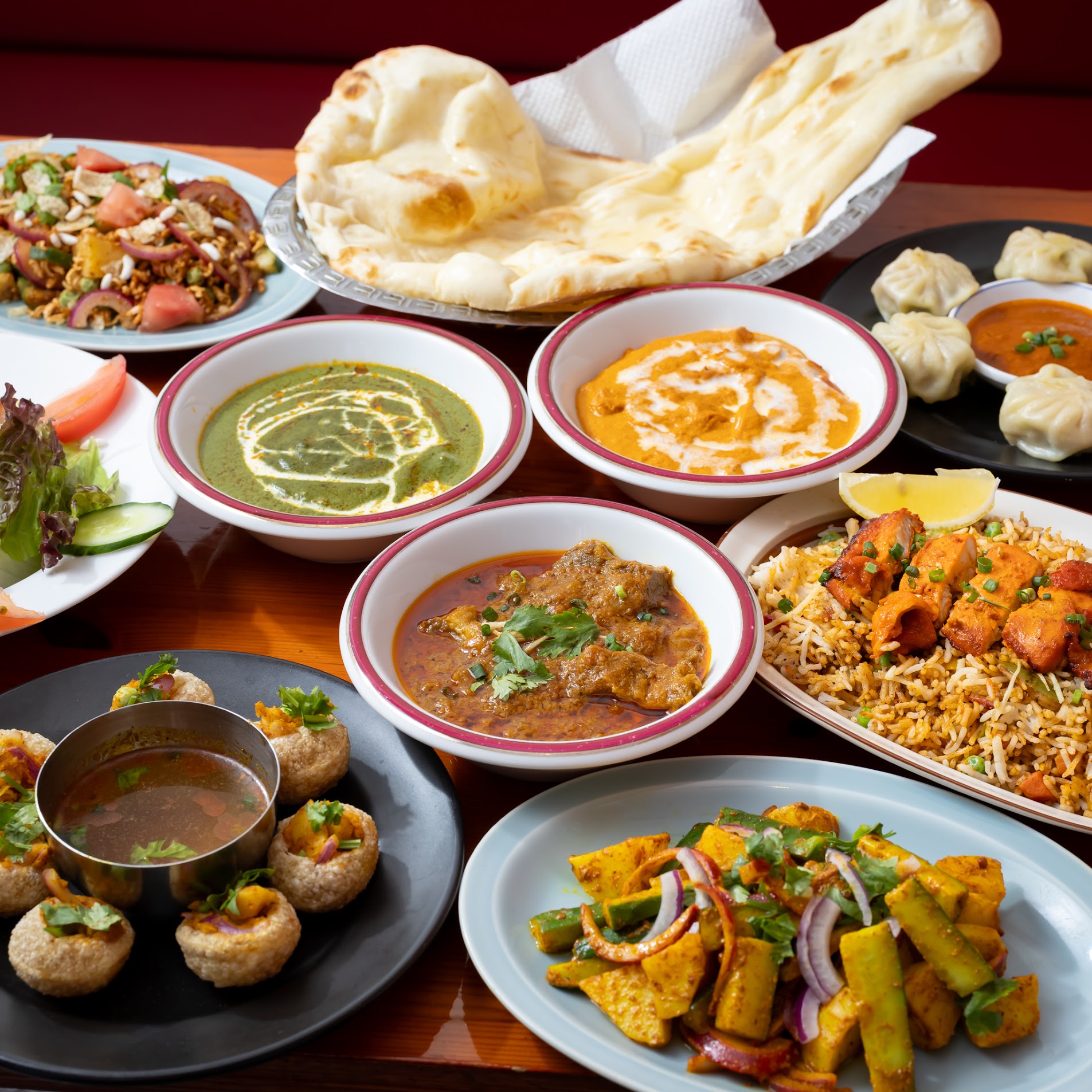 カレー、ナン、モモ、ビリヤニ、パニプリが並ぶマジックキッチンの料理の集合写真